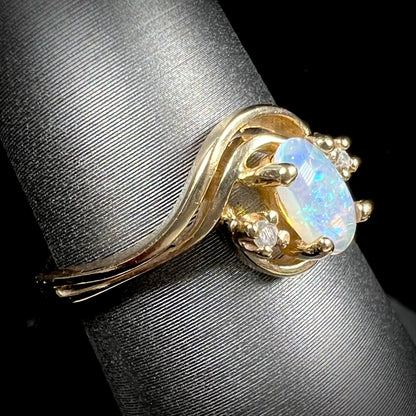 A dainty ladies' yellow gold opal and diamond accent ring.