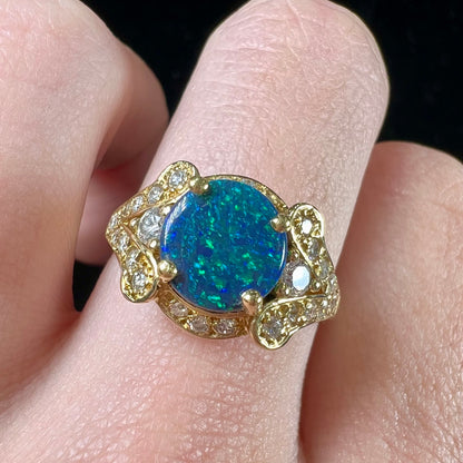 A ladies' 18kt yellow gold Lightning Ridge black opal and pave set diamond ring.