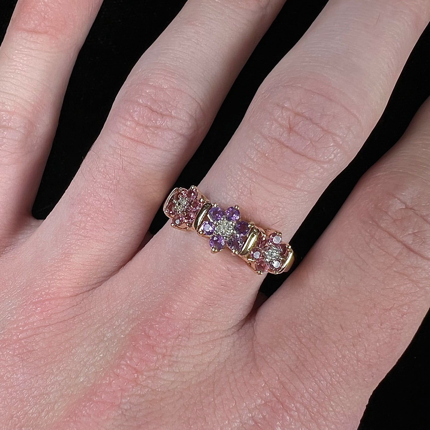 A vintage ladies' flower ring set with set with amethyst and pink tourmaline petals with a diamond center stone.