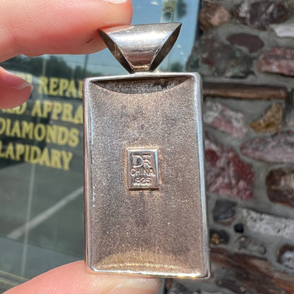 A silver pendant set with square cabochon cut turquoise and coral stones.  The piece is stamped "DTR CHINA".