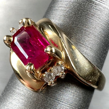 Emerald cut Burma ruby and diamond ring set in 14 karat yellow gold.