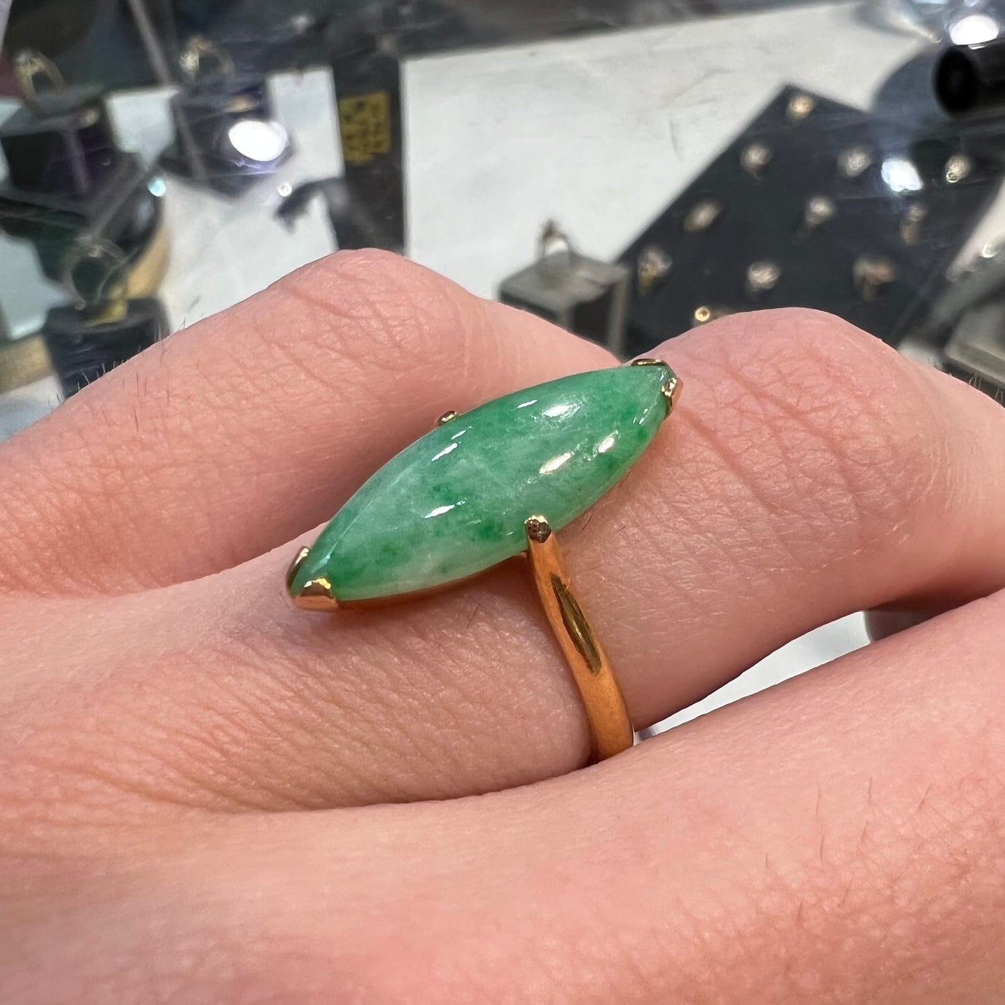 A 22 karat yellow gold solitaire ring set with a marquise cabochon cut green jadeite.