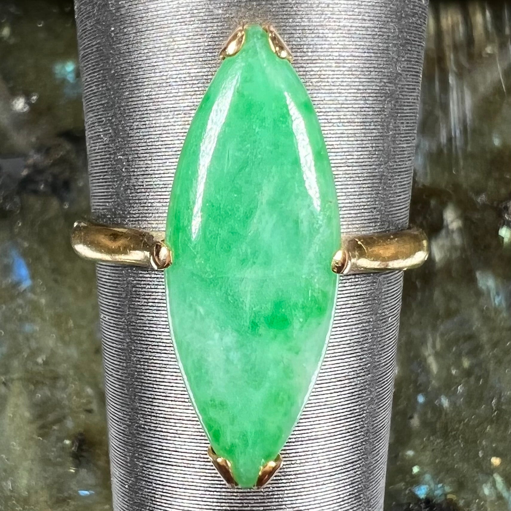 A 22 karat yellow gold solitaire ring set with a marquise cabochon cut green jadeite.