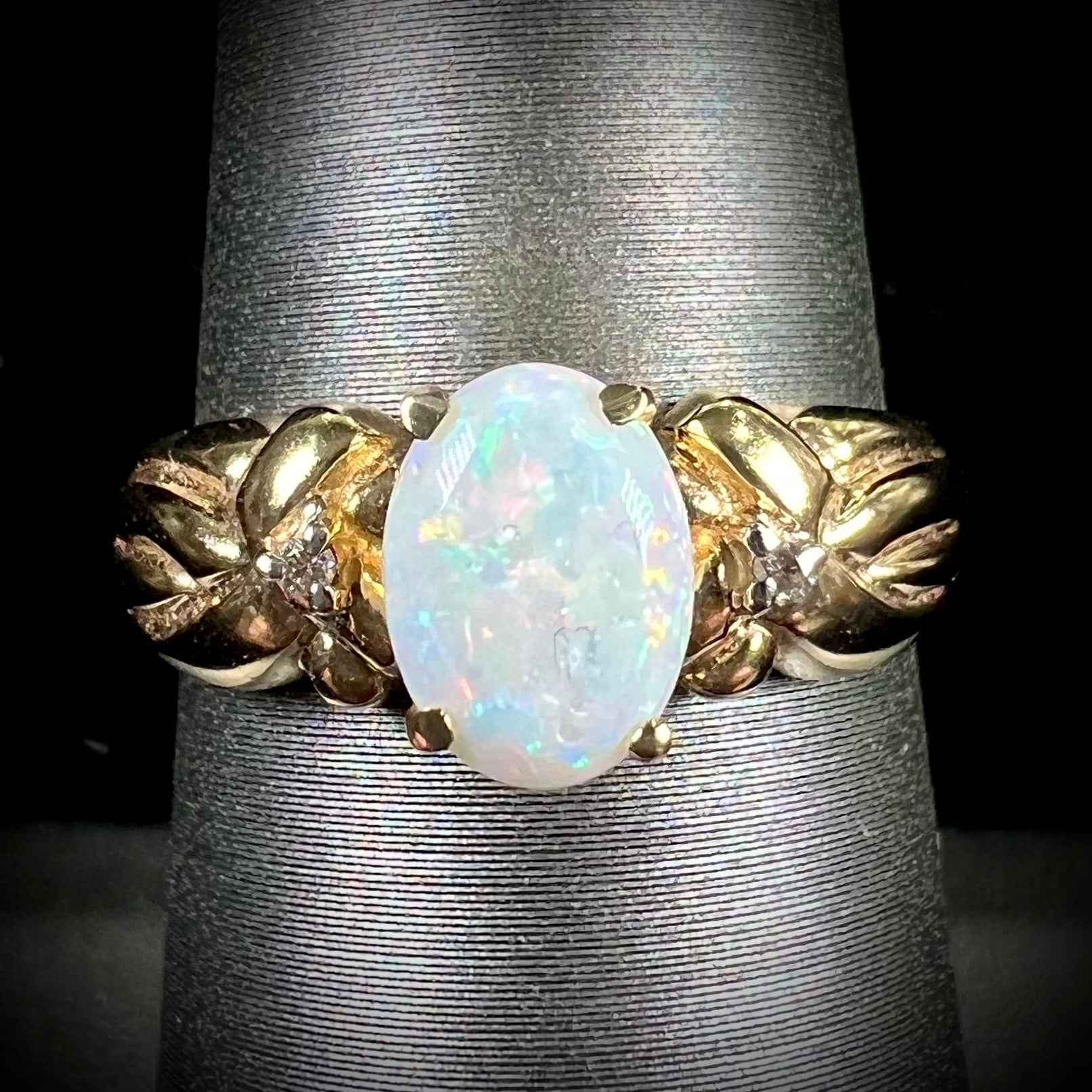 A ladies' yellow gold white crystal opal and diamond ring.  The opal is prong set.