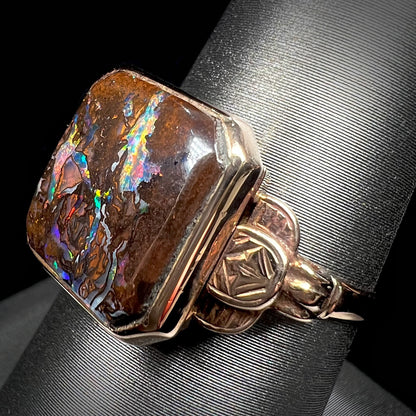 An antique yellow gold boulder opal ring.  The stone is a sqaure cut natural opal from Quilpie, Australia.