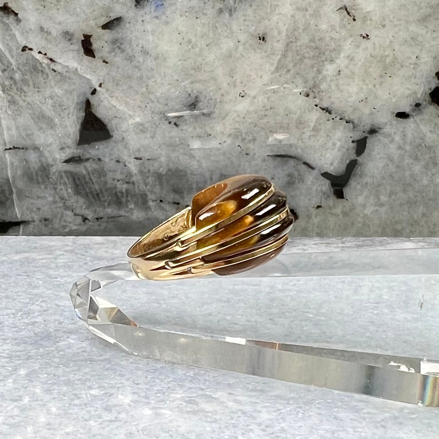 A ladies' high dome carved tiger's eye ring cast in yellow gold.