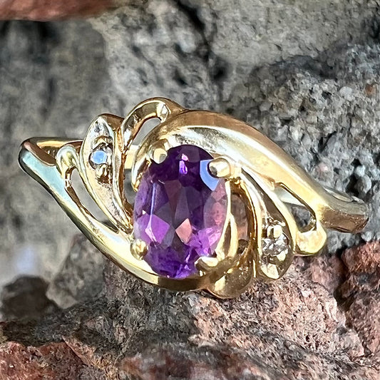 A yellow gold oval cut amethyst and diamond accent ladies' ring.