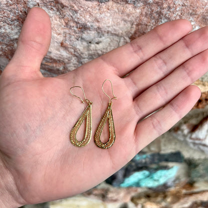 A pair of pear shape yellow gold filigree dangle earrings.