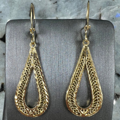 A pair of pear shape yellow gold filigree dangle earrings.