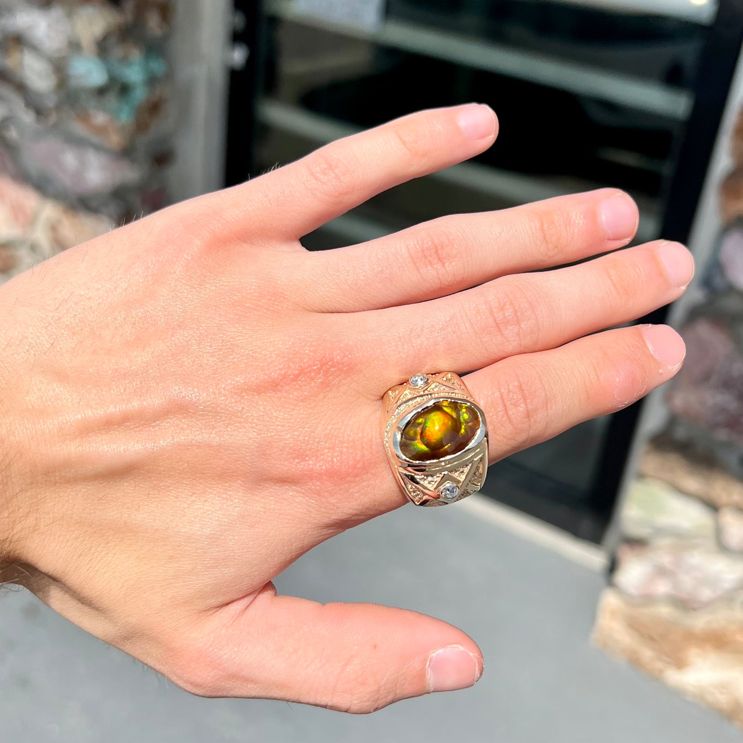 A men's solid yellow gold fire agate and diamond ring.  The fire agate displays predominantly red and green.