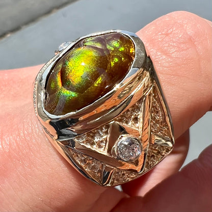 A men's solid yellow gold fire agate and diamond ring.  The fire agate displays predominantly red and green.