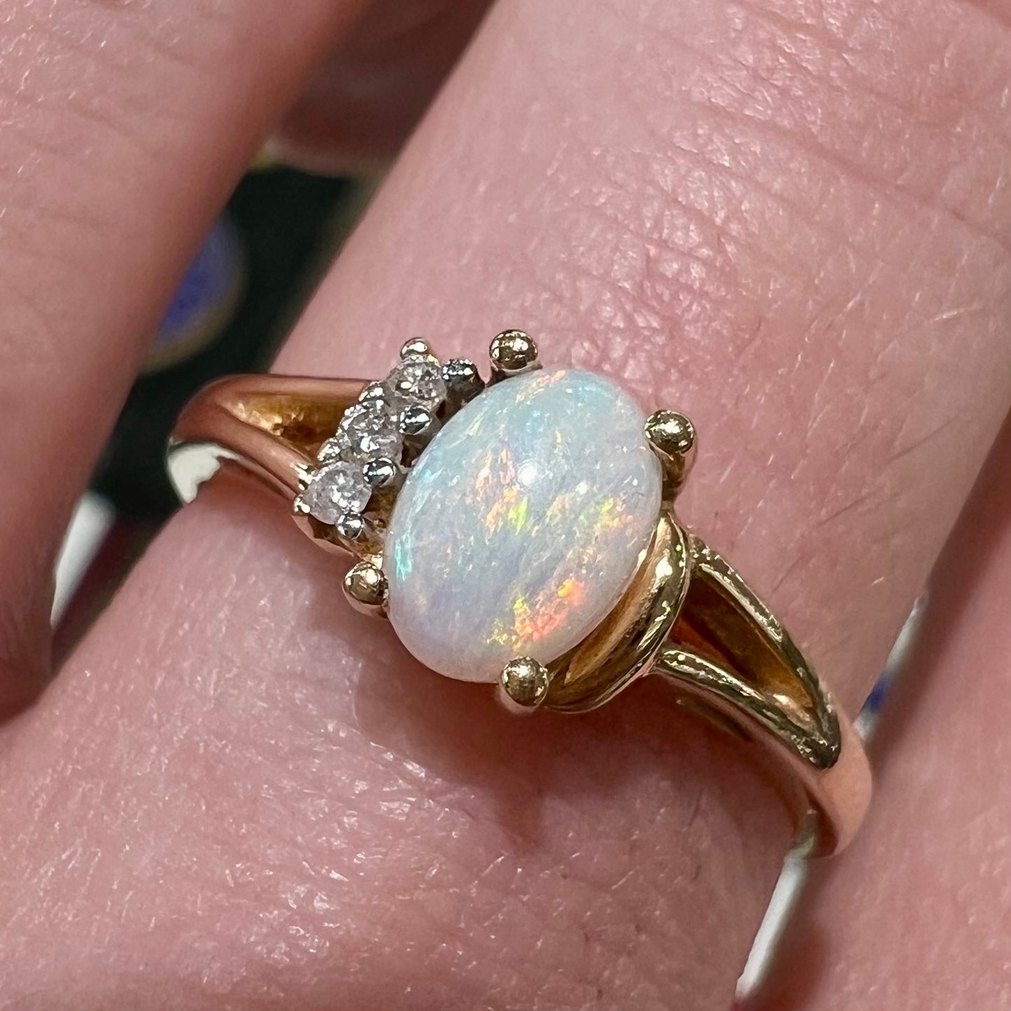 A ladies' yellow gold Coober Pedy, Australian opal ring set with three round cut diamonds.