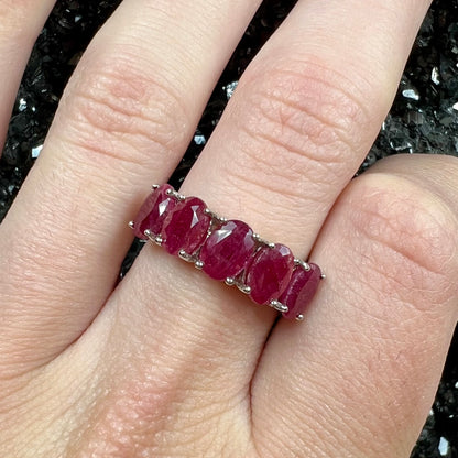 A sterling silver, five stone, faceted oval cut red ruby stackable ring.