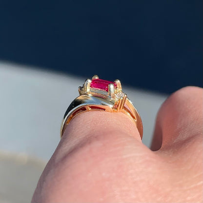 Emerald cut Burma ruby and diamond ring set in 14 karat yellow gold.