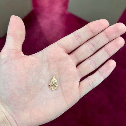 A small gold clown pendant charm.  The clown's face and hat are yellow gold, and his neck frills are rose gold.