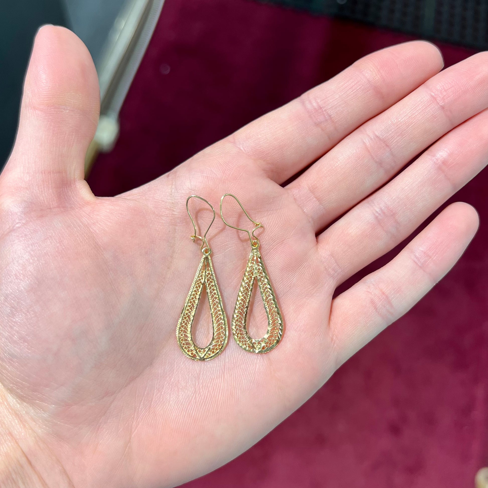 A pair of pear shape yellow gold filigree dangle earrings.