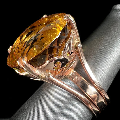 A rose gold solitaire ring set with a 51.20 carat round brilliant cut golden beryl stone.