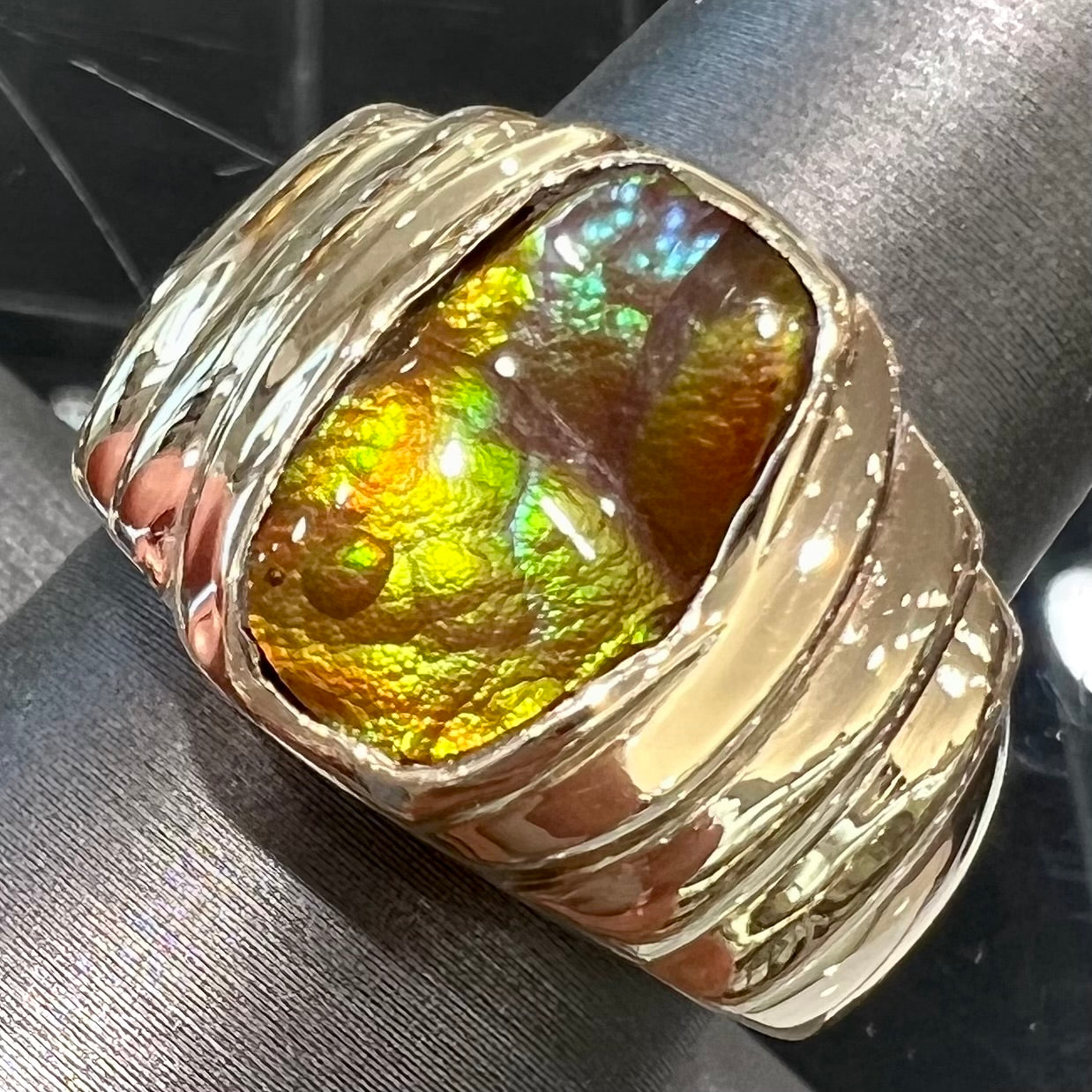 Men's fire agate solitaire ring cast in yellow gold.  The ring is a step design.