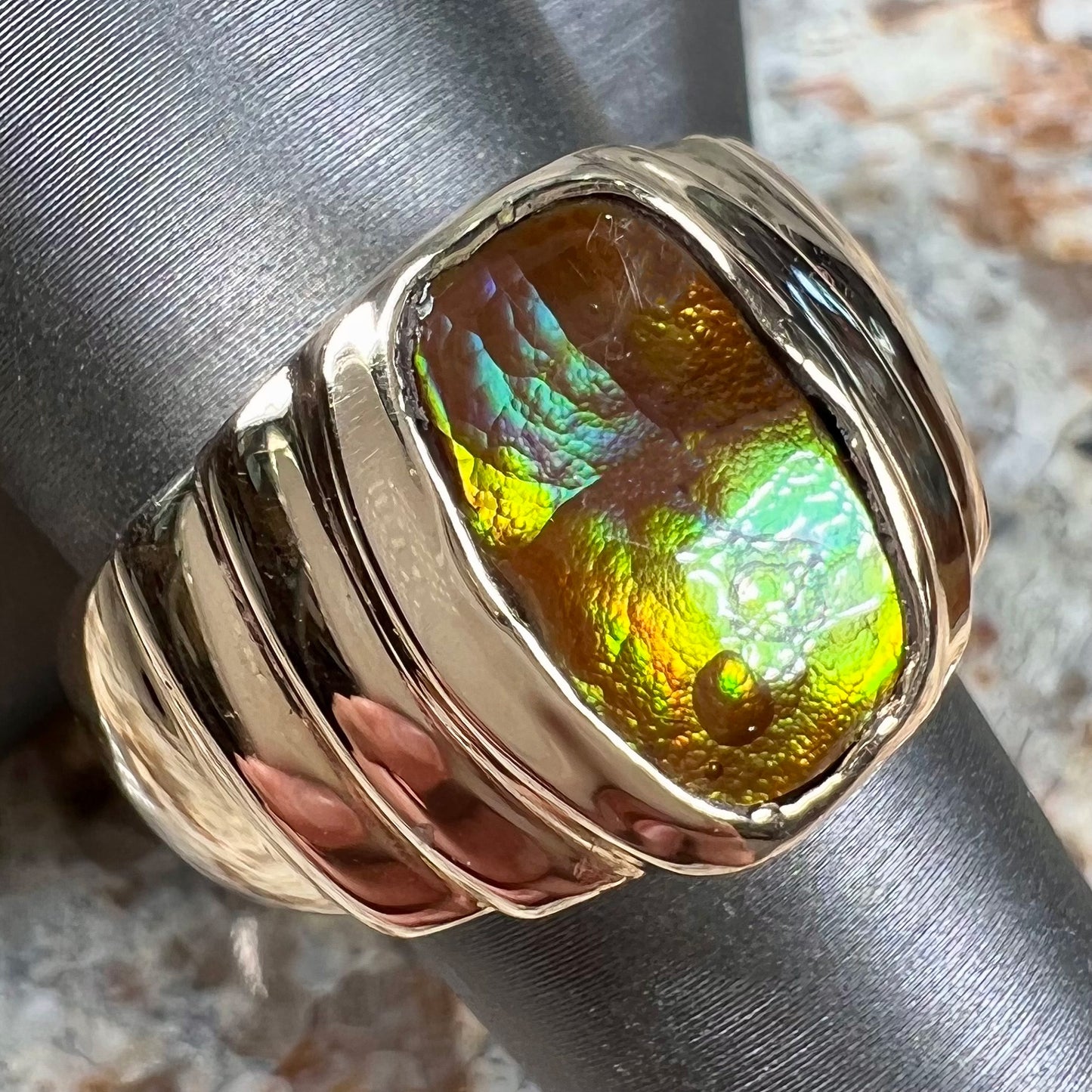 Men's fire agate solitaire ring cast in yellow gold.  The ring is a step design.