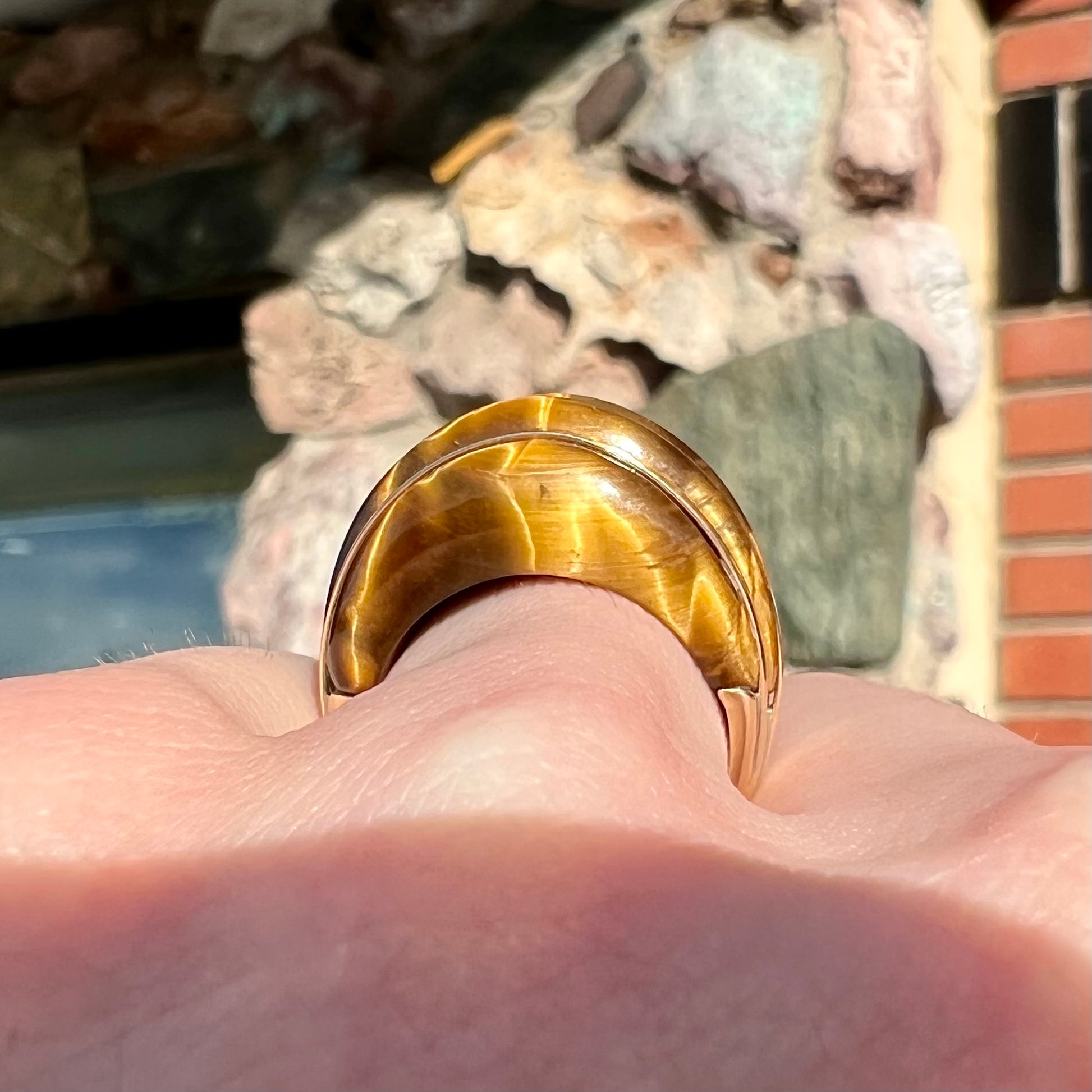 A ladies' high dome carved tiger's eye ring cast in yellow gold.