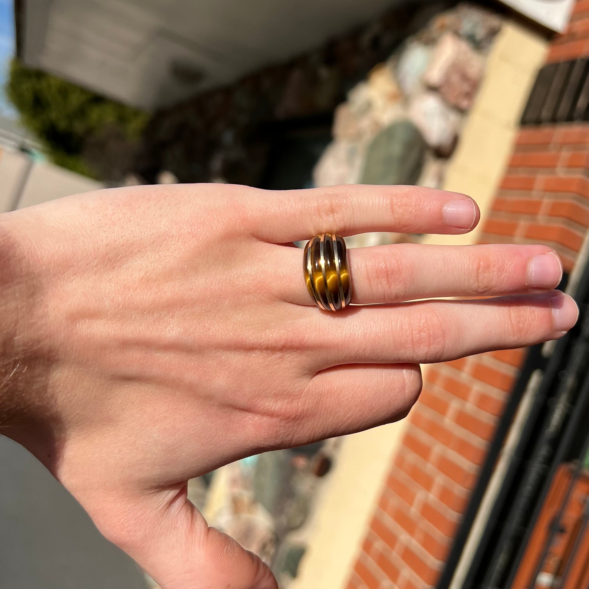 A ladies' high dome carved tiger's eye ring cast in yellow gold.