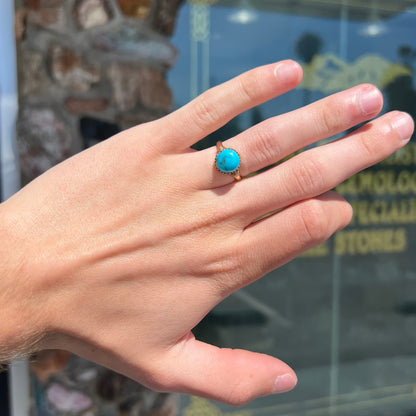 A ladies' yellow gold turquoise ring.  The turquoise is a round cabochon cut.