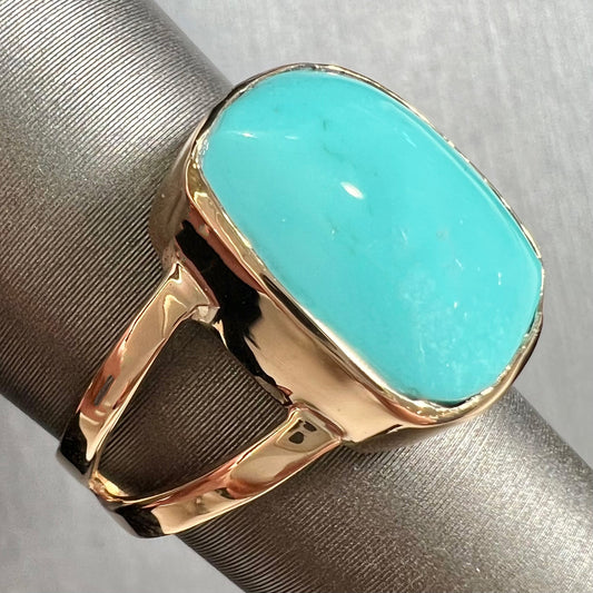 A handmade split shank ring set with Sleeping Beauty turquoise in yellow gold.