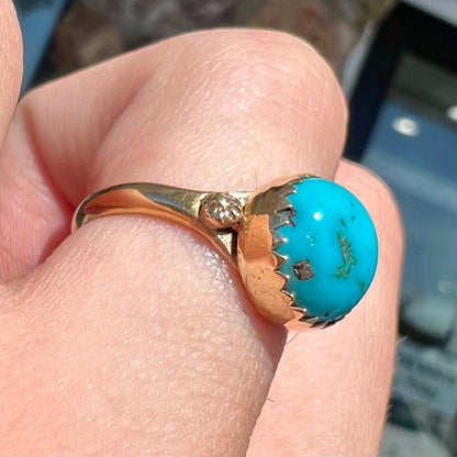 A ladies' yellow gold turquoise ring.  The turquoise is a round cabochon cut.