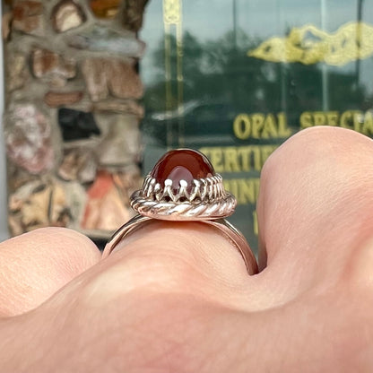 A split shank silver ring set with a brown sard stone in a rope bezel with small prongs.