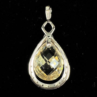 A ladies' white gold pendant set with diamonds and a faceted brilloette cut yellowish green heliodor beryl stone.