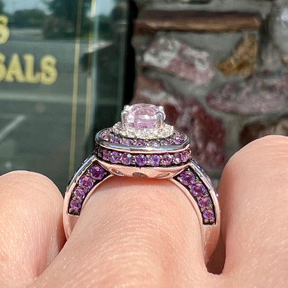 A sterling silver oval cut kunzite ring set with a double halo of round cut CZ and amethysts.