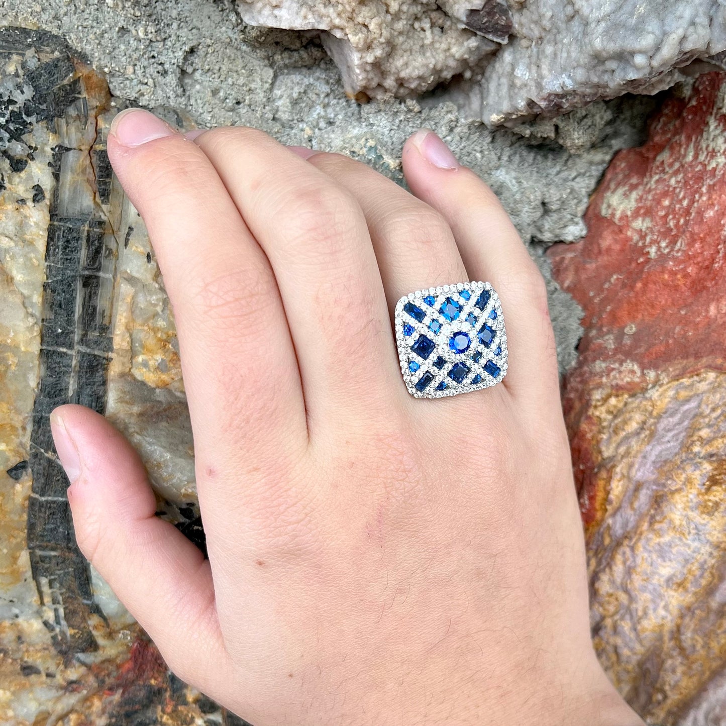 A sterling silver blue and white synthetic stone ring.  The ring strongly resembles a blueberry pie.