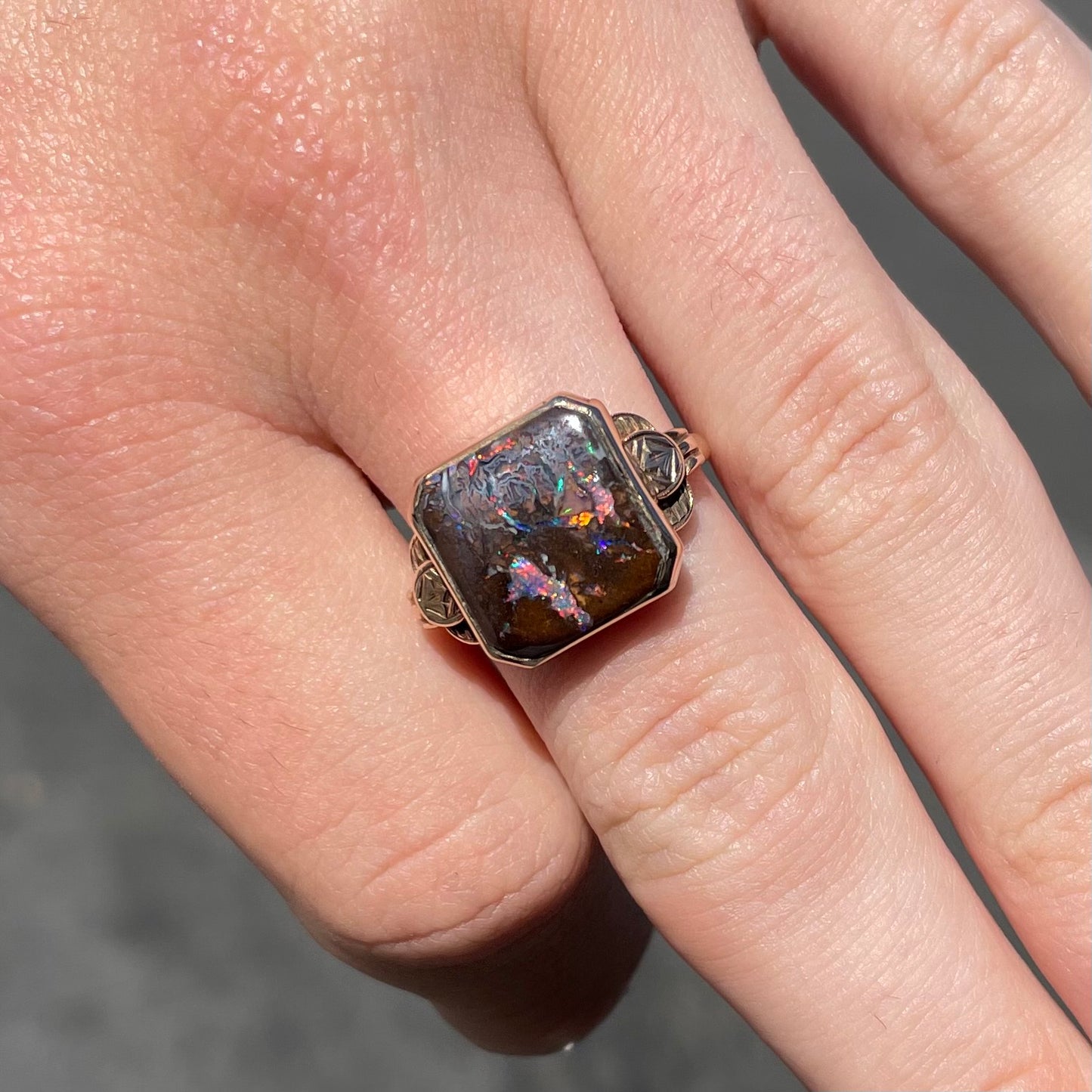 A square cut Australian boulder opal set in an antique ladies' yellow gold ring.