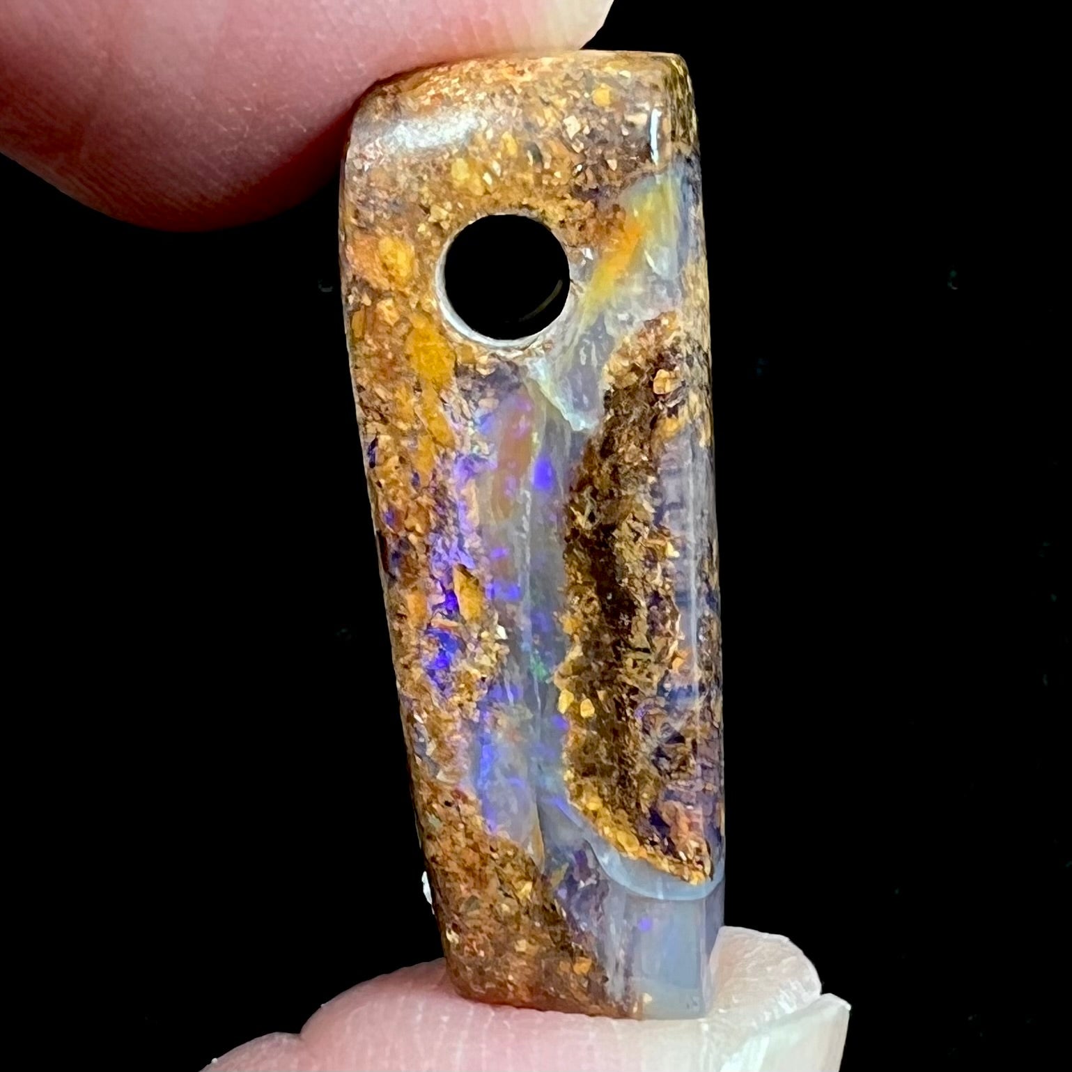 A polished, drilled pipe boulder opal bead.