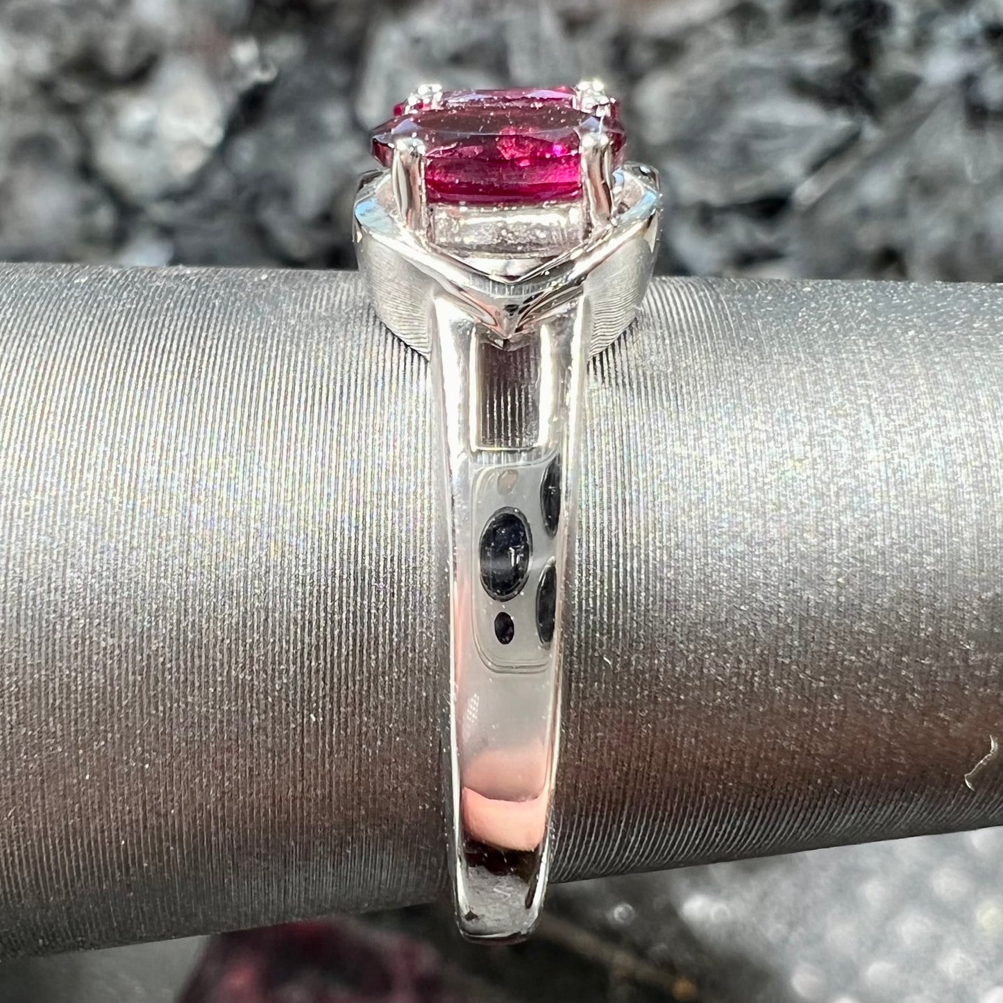 A three stone past, present, and future purple faceted oval cut rhodolite garnet ring.