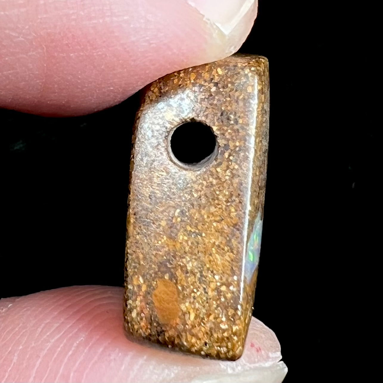 A polished, drilled pipe boulder opal bead.