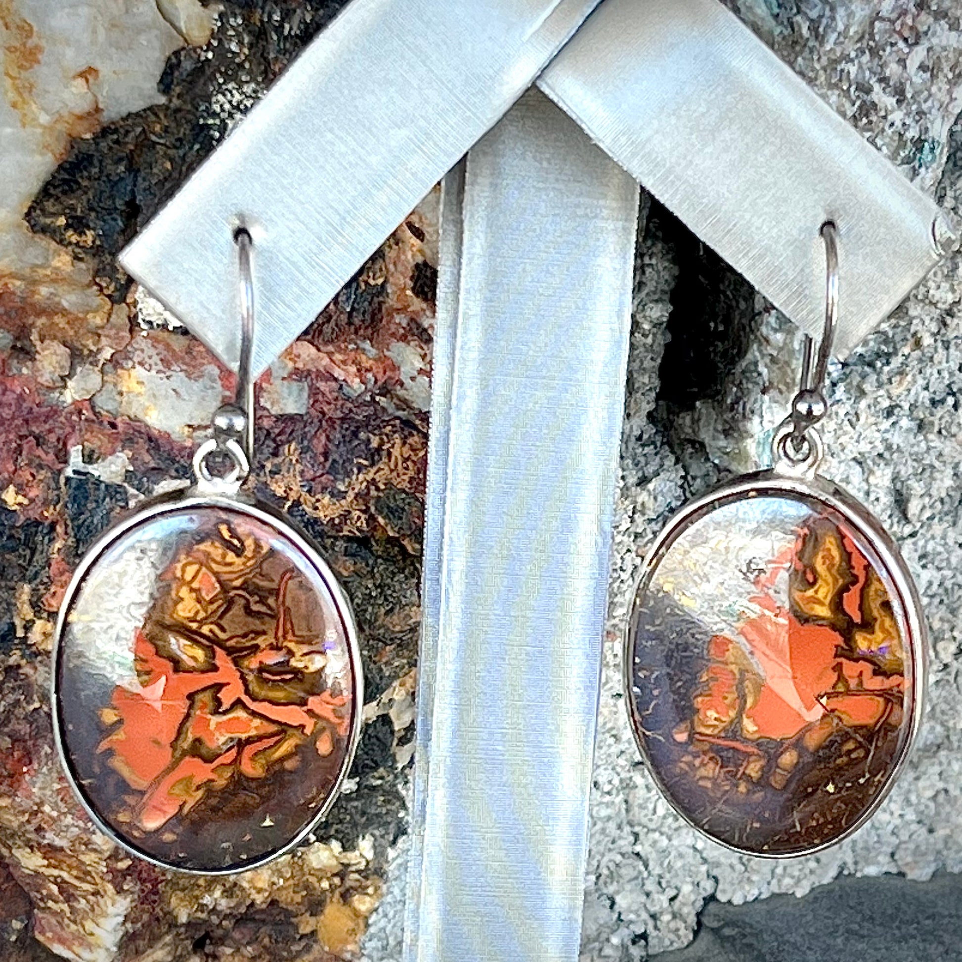 A pair of bezel set, French wire boulder opal dangle earrings in sterling silver.