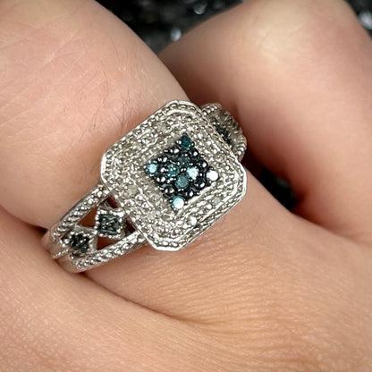 A sterling silver ring set with blue and white diamonds.