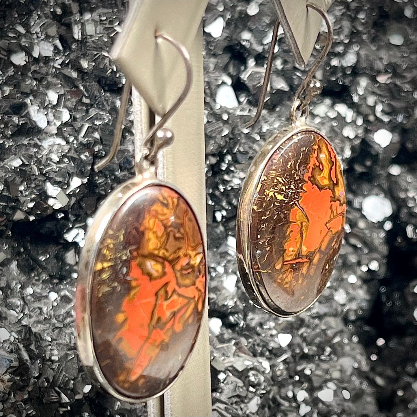 A pair of bezel set, French wire boulder opal dangle earrings in sterling silver.