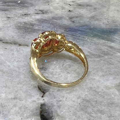 Past, present, future style red andesine feldspar and diamond halo ring cast in 14kt yellow gold.