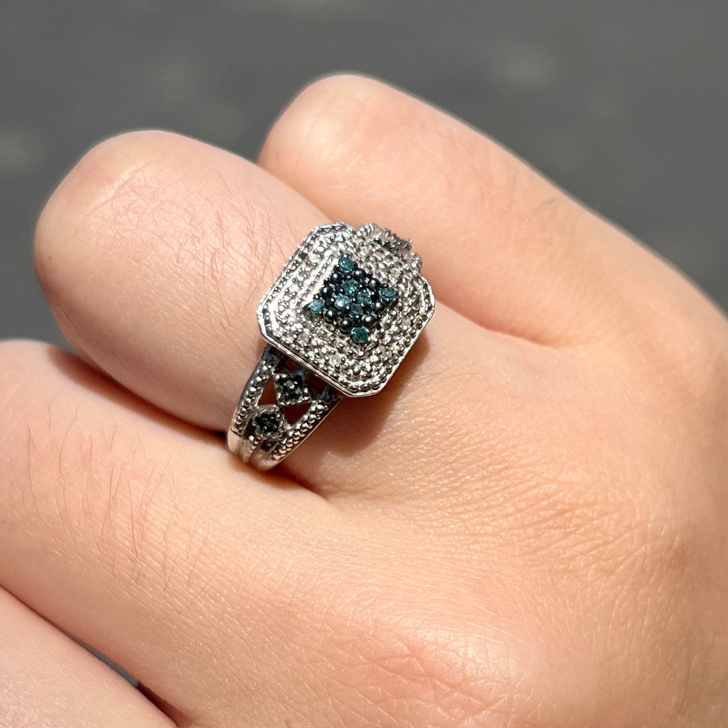 A sterling silver ring set with blue and white diamonds.