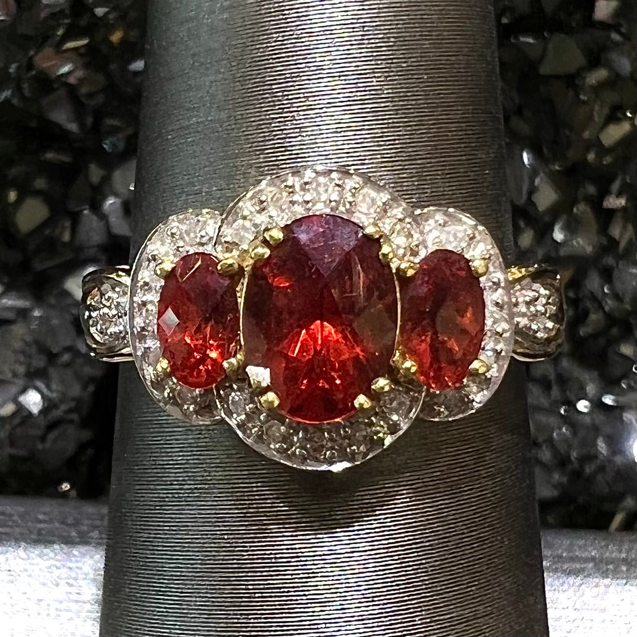 Past, present, future style red andesine feldspar and diamond halo ring cast in 14kt yellow gold.