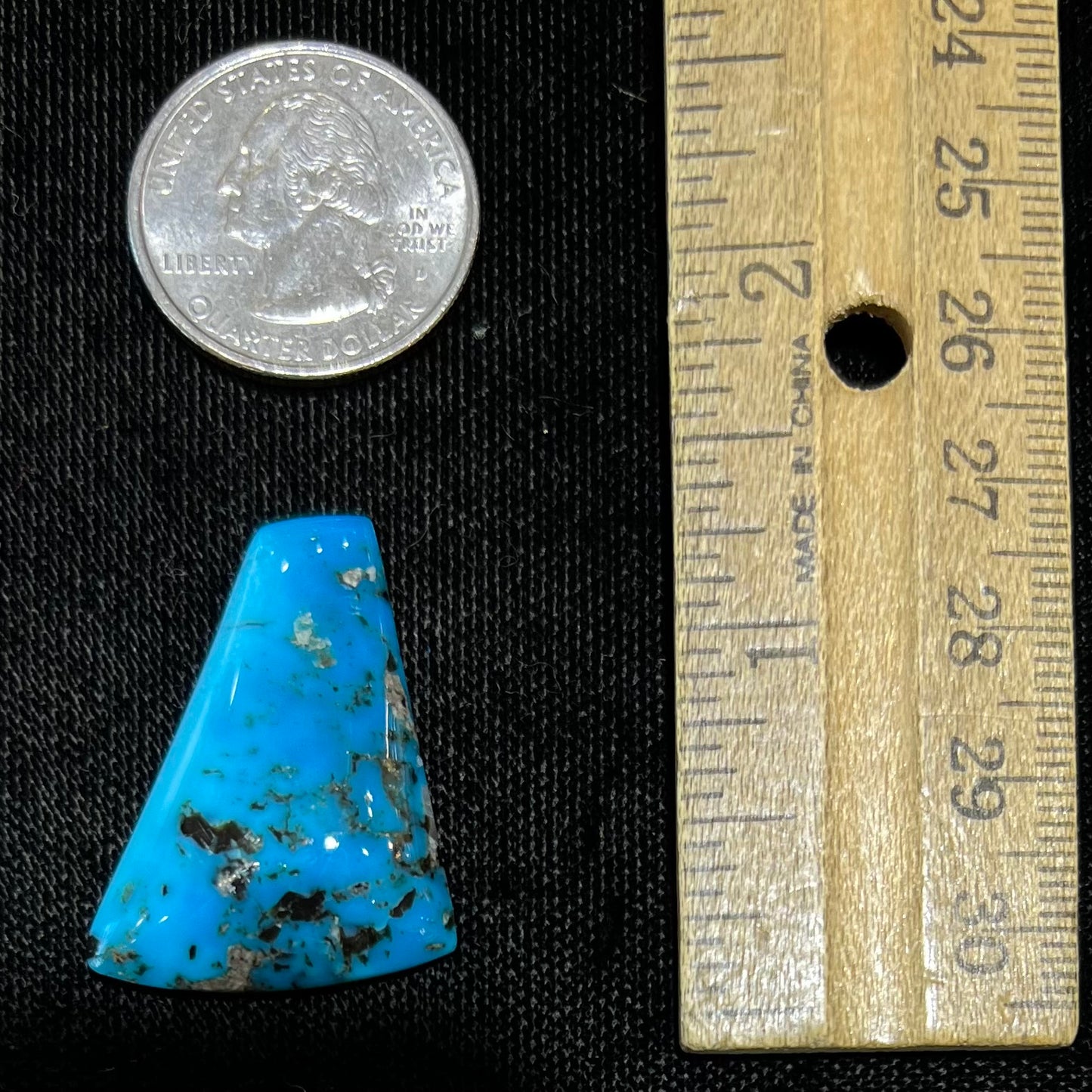 A loose, freeform triangle cabochon cut turquoise stone from the Sleeping Beauty Mine in Arizona.