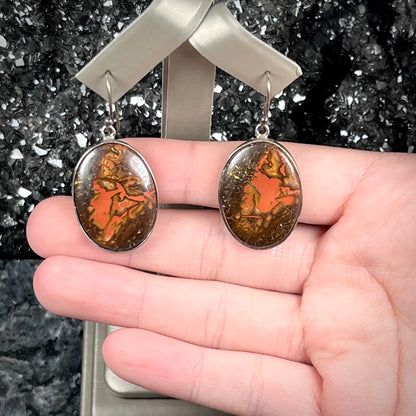 A pair of bezel set, French wire boulder opal dangle earrings in sterling silver.