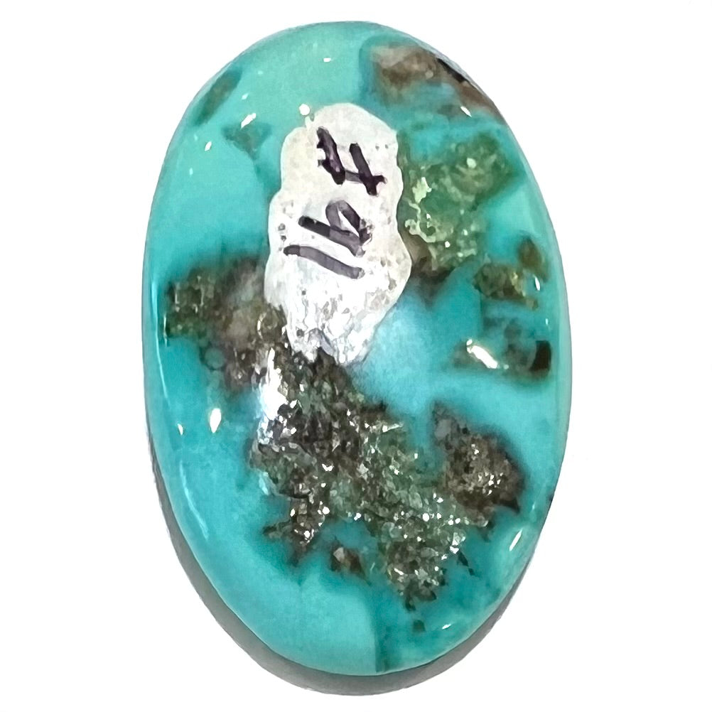 The backside of one loose oval cabochon cut turquoise stone from Pilot Mountain Mine, Nevada.