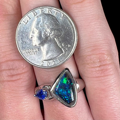 A ladies' white gold ring set with Australian black boulder opal and pear shape blue sapphire.