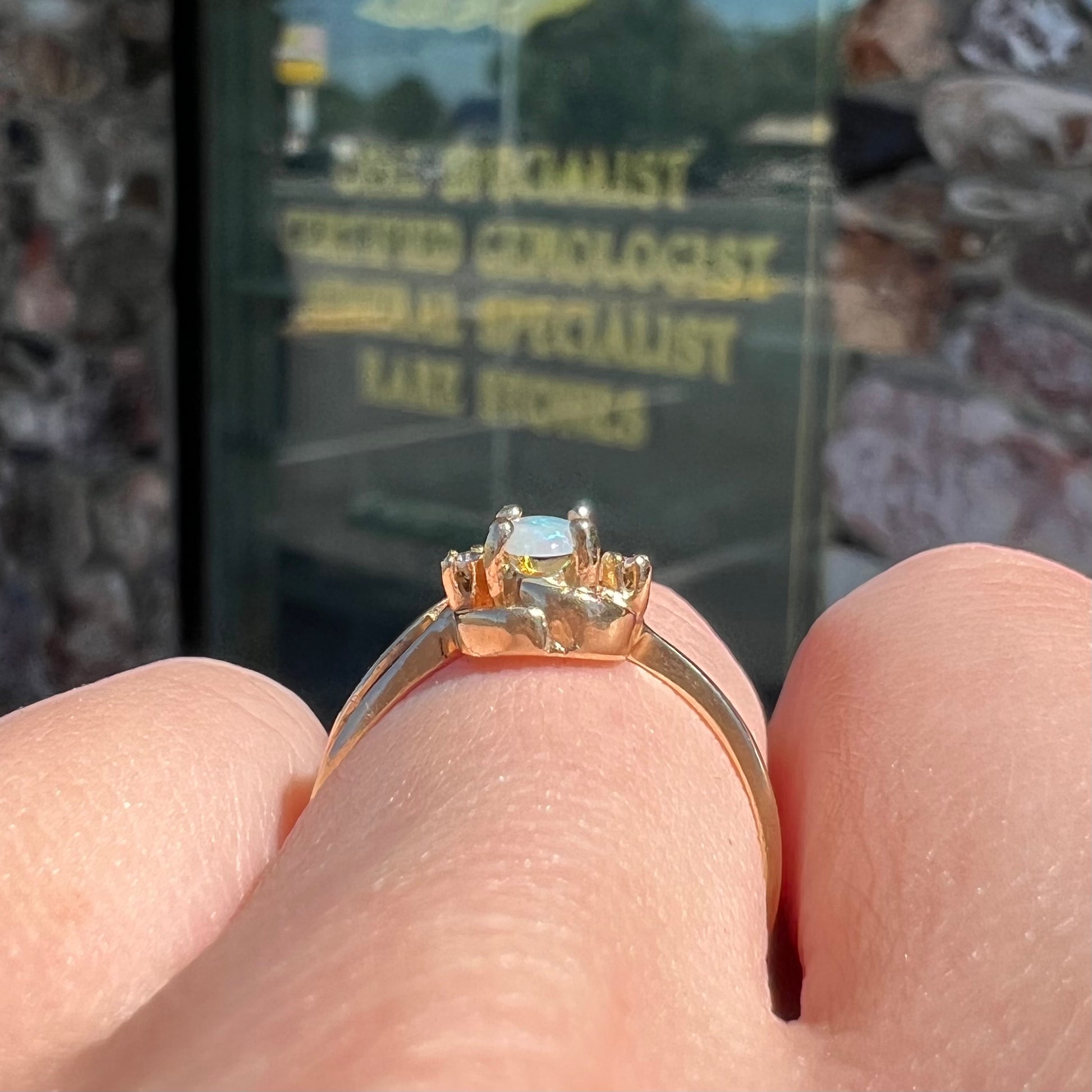 A dainty ladies' yellow gold opal and diamond accent ring.