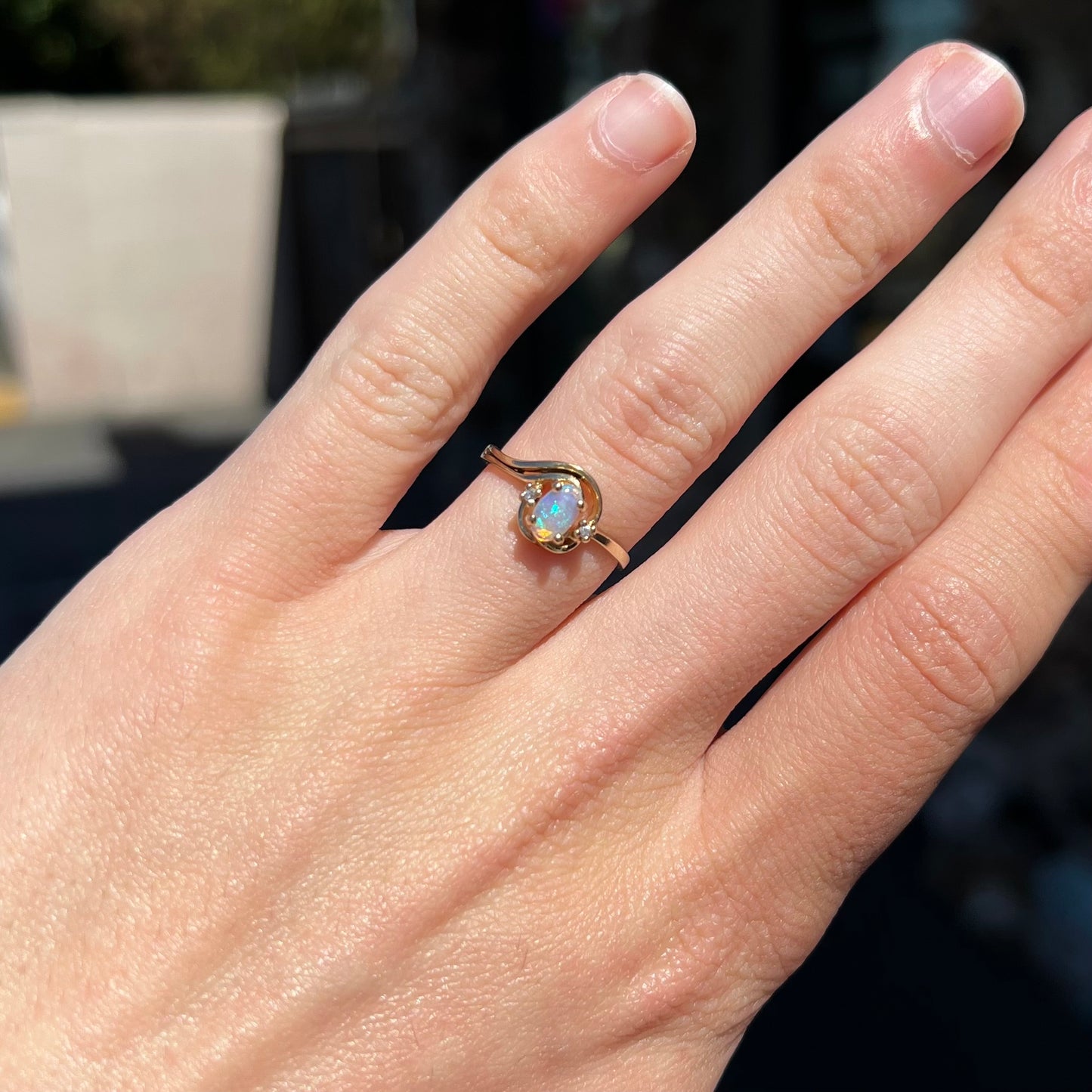 A dainty ladies' yellow gold opal and diamond accent ring.