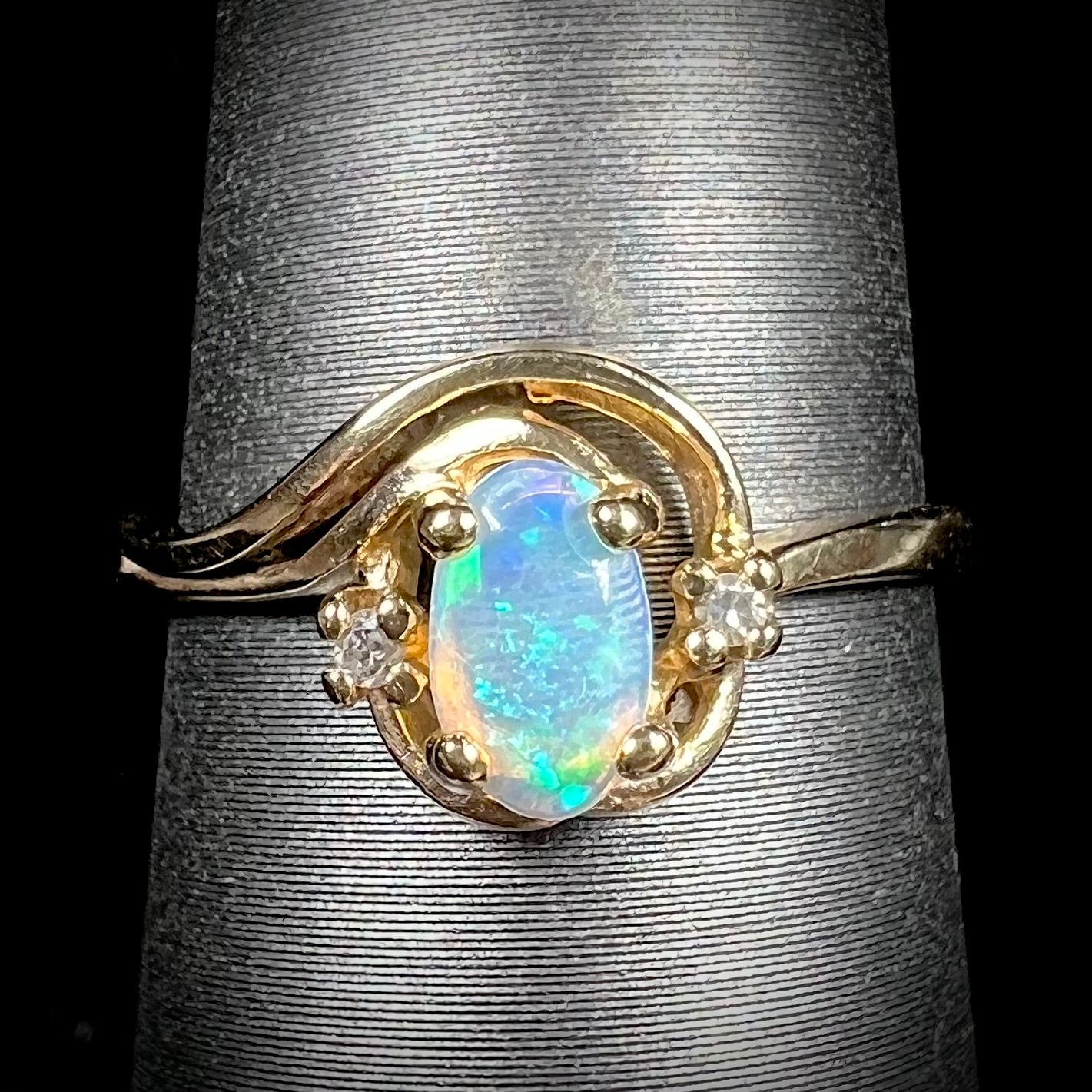 A dainty ladies' yellow gold opal and diamond accent ring.