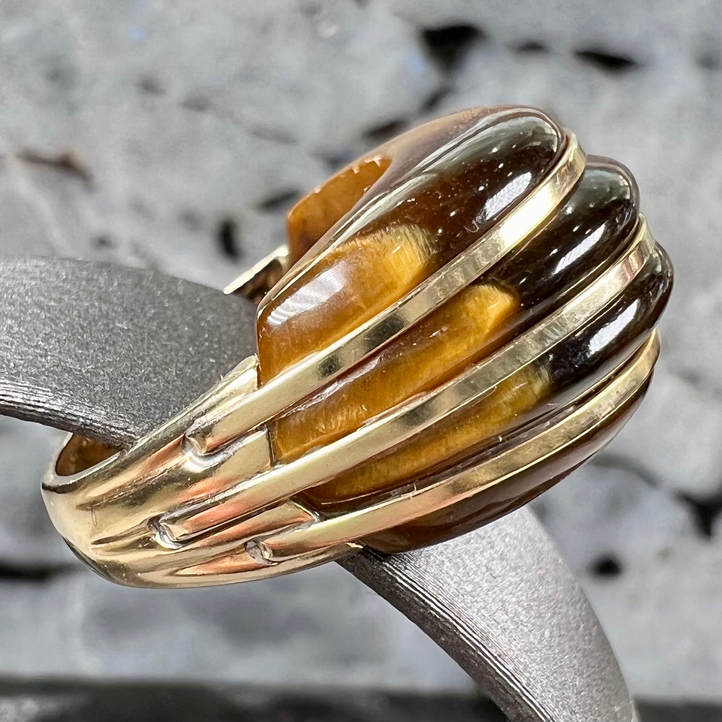 A ladies' high dome carved tiger's eye ring cast in yellow gold.